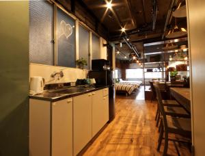 名古屋Guest House Re-worth Yabacho1 1F的一个带水槽的厨房和一间客厅