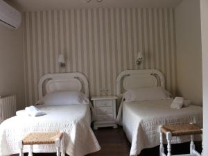ArenHotel Domenc的酒店客房,配有两张床和两把椅子