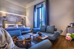 佛罗伦萨Palazzo dei Conti Residenza d'Epoca的客厅配有蓝色家具和床