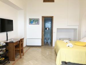 普莱伊亚诺Residence Lì Galli的酒店客房设有两张床、一张桌子和一台电视。