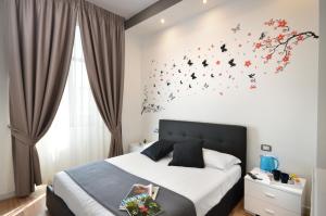 那不勒斯B&BCentral Station Napoli的卧室配有一张床上的蝴蝶壁床。