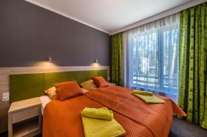 库瑞尼卡慕斯卡Hotel *** NAT Krynica Morska的一间卧室设有一张大床和一个窗户。