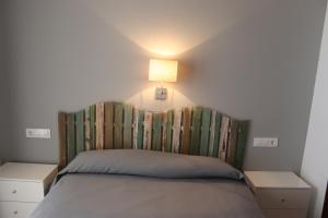 佩尼斯科拉佛罗里达II 号公寓酒店的一间卧室配有一张带床头板和灯的床