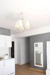 奥布佐尔Stela Apartments的厨房配有吊灯、白色橱柜和镜子