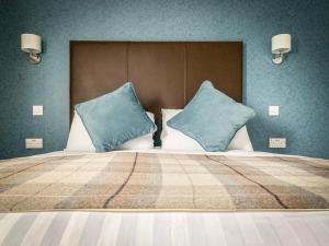 斯特灵罗伯特国王酒店的一张大床,上面有蓝色枕头