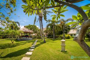 BanjarVilla Segara Murti - Stylish Beachfront Villa!的种有棕榈树的花园