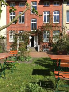 吕讷堡Villa Friedenstraße 11的草丛中带野餐桌和椅子的建筑