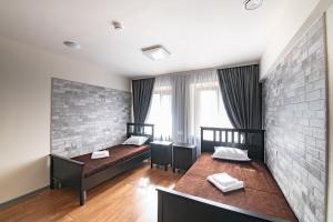 符拉迪沃斯托克1915 Hostel的一间卧室设有两张床和砖墙