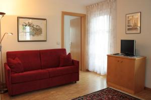 雷西亚Appartement Prieth的客厅配有红色沙发和电视