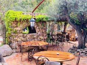 维琪奥港Ranch Campo Palombaggia的一个带桌椅的庭院和石墙