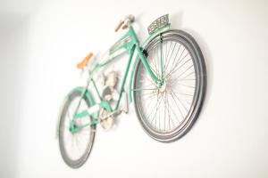 萨格里什Sagres Sun Stay - Surf Camp & Hostel的一辆绿色自行车挂在墙上