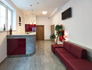 卢布林HOTEL LUBLIN的一间带红色沙发的客厅和一间厨房
