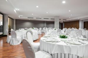 卡塞雷斯卡塞雷斯伊科斯阿戈拉酒店的宴会厅配有白色的桌椅