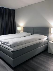 纳沙泰尔勒克鲁斯酒店的卧室内的一张大床,配有两盏灯