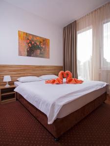 布拉迪斯拉发布拉迪斯拉发加尼飞行员酒店的一间卧室配有一张大床,上面有橙色毛巾
