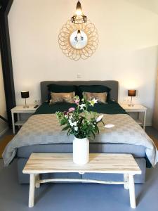 RuinenB&B De Achterdiek的一间卧室配有一张床和一张鲜花桌子