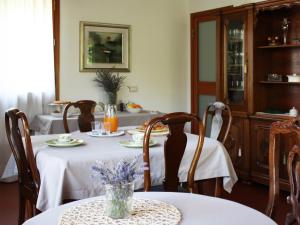 里乔内Bed And Breakfast 22 Garibaldi Home的一间用餐室,配有2张带白色桌布的桌子