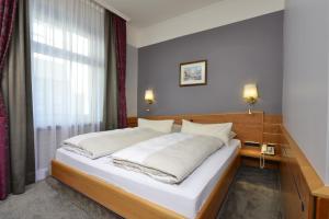 慕尼黑图芭拉乌酒店的卧室设有一张白色大床和一扇窗户。