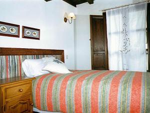 Casas del CastañarCasa Rural La Cueva的一间卧室配有一张床、一个梳妆台和一扇窗户。