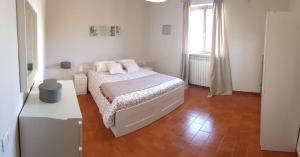 莱波拉诺Villa Fioroni的白色的卧室设有床和窗户