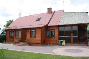 比亚沃维耶扎Kama Pokoje Gościnne的一间红色屋顶的木屋