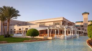 沙姆沙伊赫Coral Sea Holiday Resort and Aqua Park的大楼前设有游泳池的酒店
