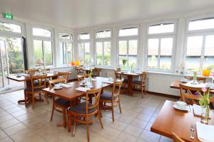 DeinsteStade Land Golf Hotel的餐厅设有桌椅和窗户。