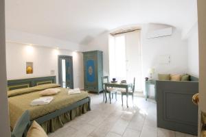 加利波利Duomo Gallipoli B&B and Apartments的一间卧室配有一张床、一张桌子和一张桌子