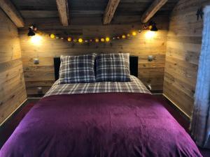 蒂涅le mazot d'urbain的小木屋内一间卧室,配有一张床