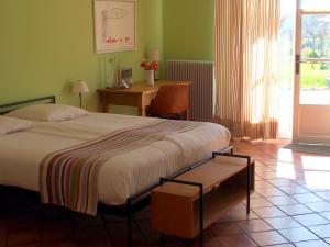 圣洛朗迪韦尔东磨坊城堡酒店的卧室配有1张床、1张桌子和1把椅子