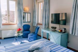 佩切图好斯蒂勒瑞杜高尔夫酒店的一间卧室配有一张床、一台电视和一把椅子