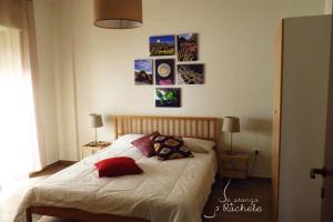 那不勒斯La Stanza di Rachele的一间卧室配有一张带枕头的床,墙上挂有图片