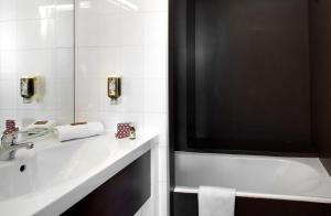 卡西斯皇家小别墅酒店的浴室配有盥洗盆和浴缸。