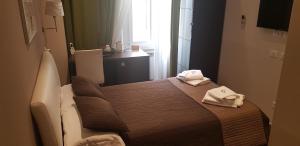 罗马米娅套房酒店的小房间,配有带毛巾的床