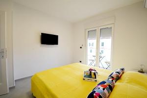 乌马格La Piazza的一间卧室配有黄色的床和电视
