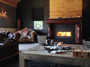 威布林Luxurious Villa in Houffalize with Sauna的客厅设有壁炉和带蜡烛的桌子。