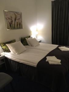 诺尔雪平Hotell Drott的一张大床,位于酒店客房内,配有毛巾
