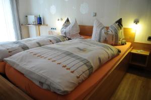 于尔齐希佩特拉旅馆的一间卧室配有两张带白色毯子和枕头的床