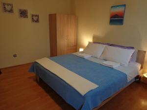 普莱曼图拉Guesthouse Aotearoa Premantura的一间卧室配有一张带蓝白色床单的大床