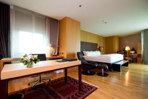 曼谷Maduzi Hotel, Bangkok - Asoke的酒店客房配有一张床、一张书桌和一张书桌。