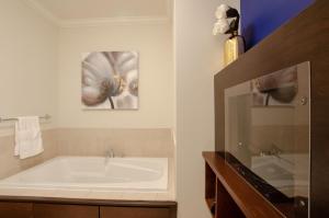 圣约翰斯首套房 - 圣约翰信号山门公寓的带浴缸的浴室和一幅花画
