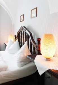 弗克拉布鲁克奥尔哈恩餐厅城市酒店的一张带白色床单的床和一张桌子上的台灯