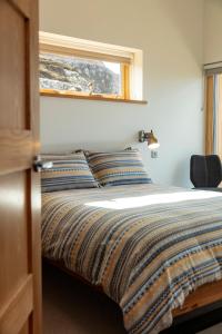 阿勒浦Tigh na Mara的一间卧室配有一张带窗户的床和一张四柱床