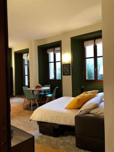 阿罗纳La Via degli Artisti的卧室配有一张床和一张桌子及椅子