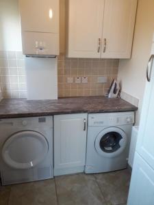 CoalislandAunt Mollie's Cottage的厨房配有洗衣机和洗衣机。