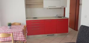 诺瓦利娅Apartments Biba的红色的厨房配有桌子和水槽