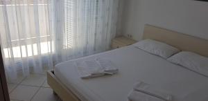 诺瓦利娅Apartments Biba的卧室内的白色床和毛巾