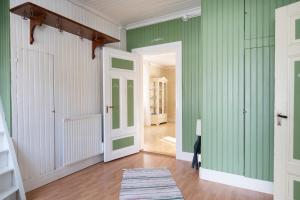 NylandTorpet i Sjö的走廊上设有绿色的墙壁和白色的门