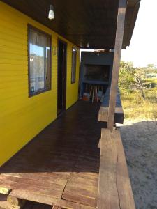 德尔迪阿布罗角法玛山林小屋的黄色的房子,设有木门廊和窗户