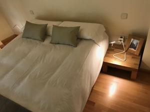 萨莫拉Atrio Zamora的一张带两个枕头和一盏灯的大型白色床